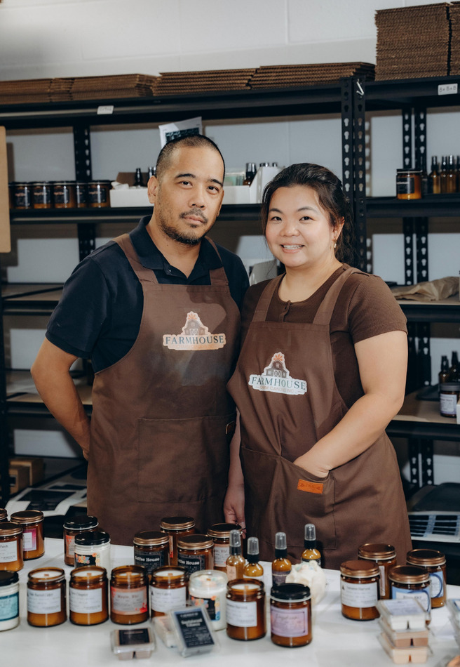 The founders of Farmhouse Charm Candle Company in their workshop, surrounded by their handmade candles