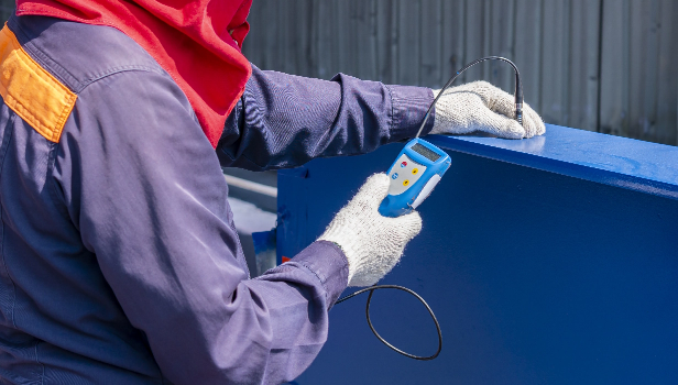 Technician testing film thickness