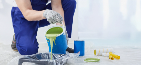 Painter pouring green paint
