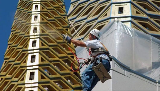 Cloverdale Paint industry updates image showing a worker performing exterior work on a commercial structure.